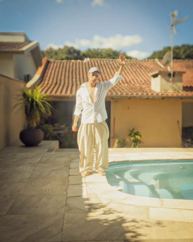 Luiz Fetter de roupa clara ao lado de uma piscina